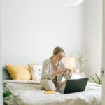 Photo of Woman Sitting on Bed While Using Smartphone